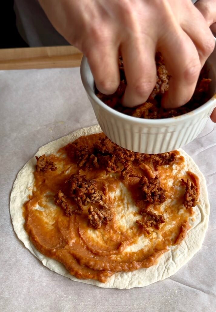 adding seasoned ground beef to mexican pizza