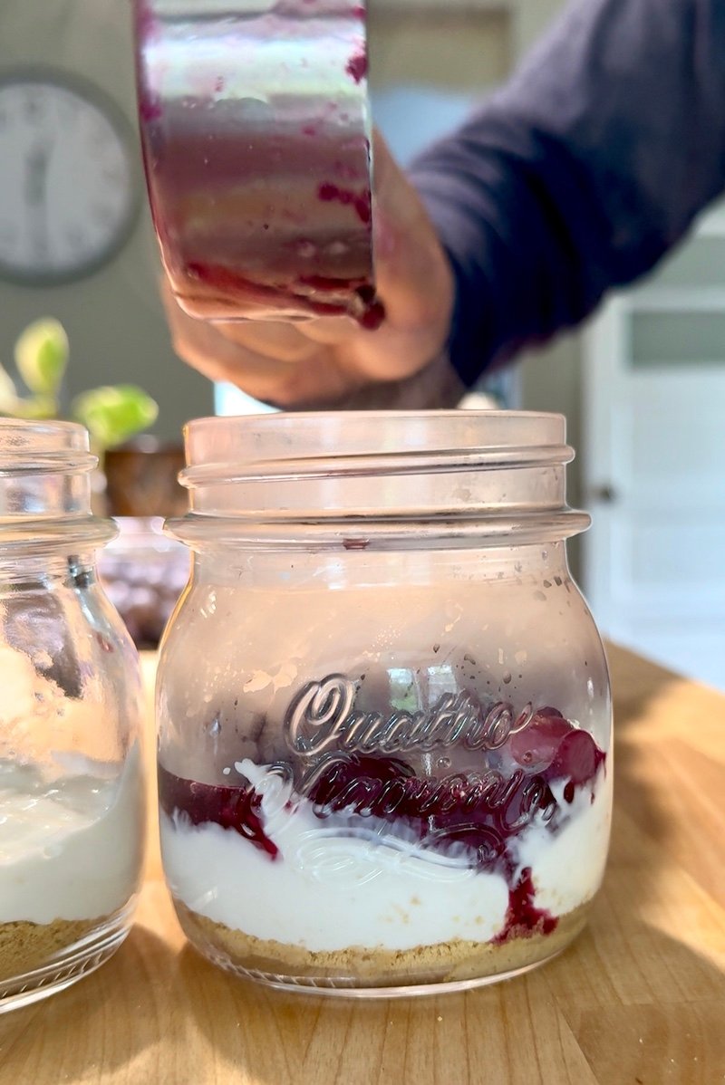 adding sauce to cheesecake jars