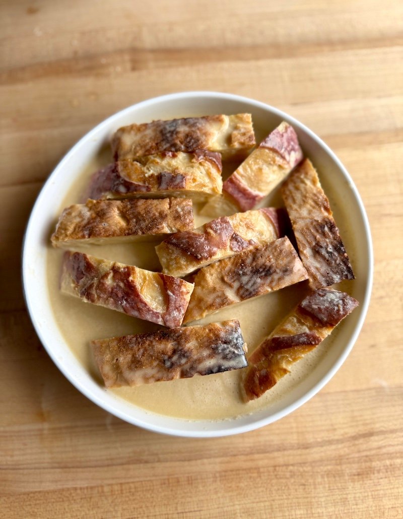 french toast sticks being soaked in milk and eggs great for meal prep