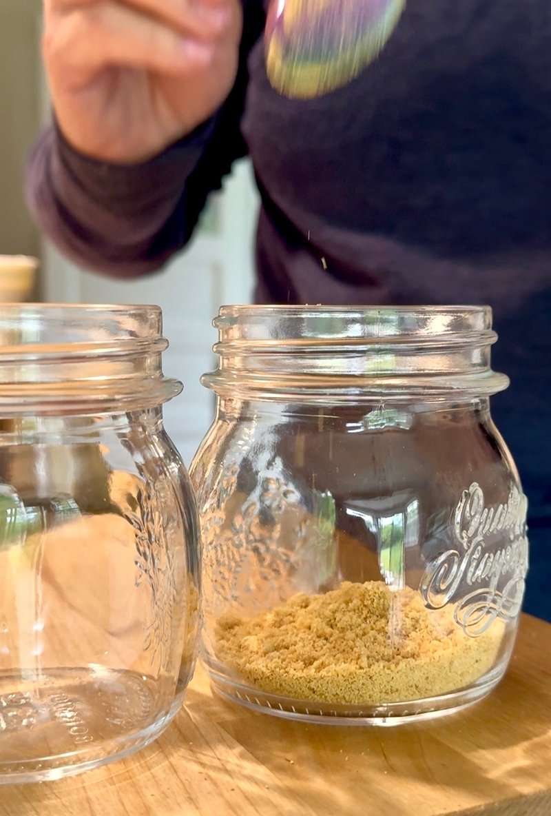 adding graham crackers to cheesecake jars