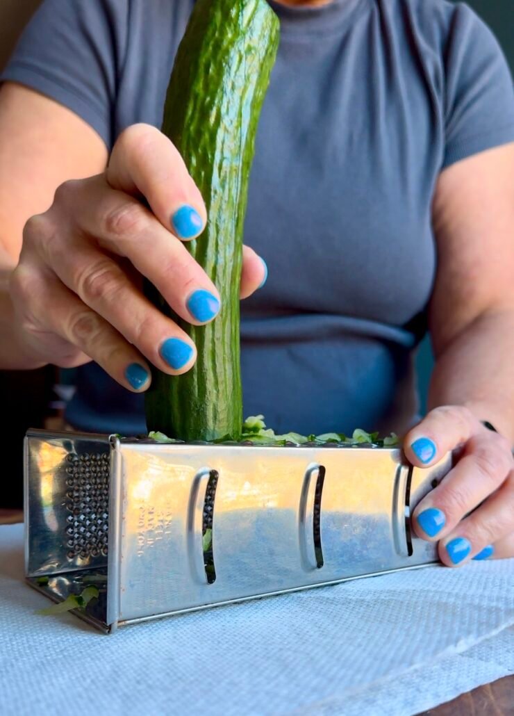 this is a cucumber being grated to make tzatziki sauce