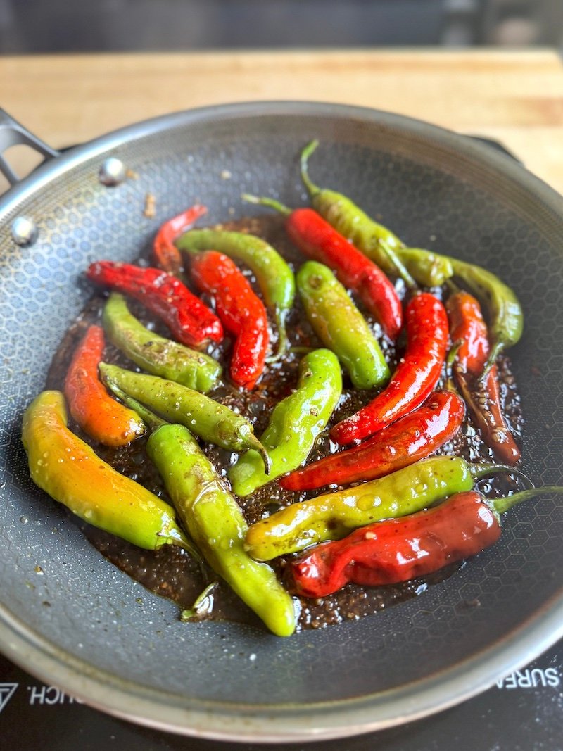 shishito peppers in a pan with Asian sauce